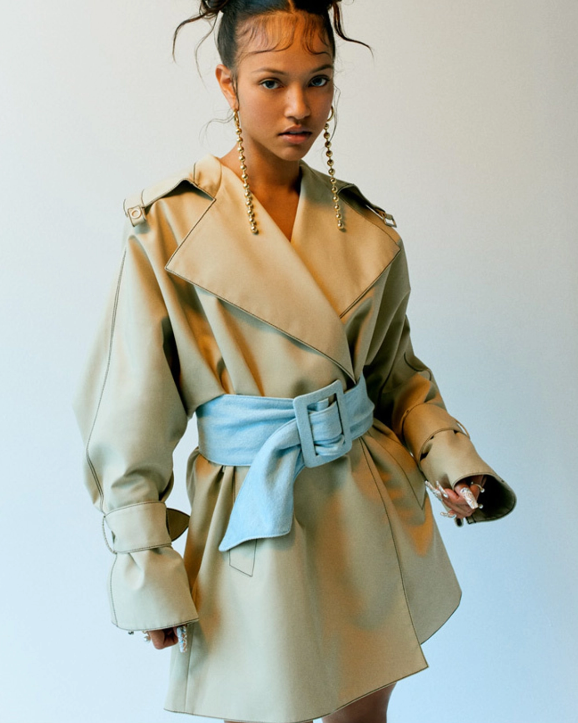 A fashion editorial page featuring a model wearing a beige and light blue outfit, with the headline 'PAPER' at the top and a text block at the bottom describing the look.